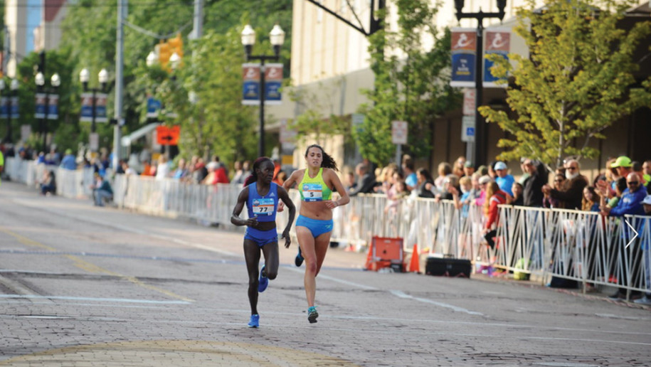 Gabi Anzalone secures 7th place among women by surging past Kenya’s Lineth Chepkuri just before the finish line of the 2017 Crim 10-mile race.